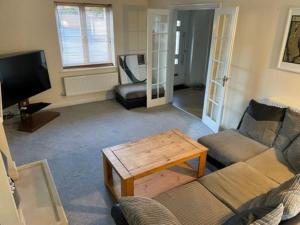 a living room with a couch and a coffee table at Large 5 Bedroom Family home with parking and WI-FI in Kettering