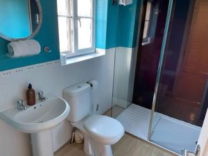 uma casa de banho com um WC, um lavatório e um chuveiro em Large 5 Bedroom Family home with parking and WI-FI em Kettering