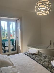 een slaapkamer met een bed, een bad en een kroonluchter bij Suite Riviera 84 in Napels