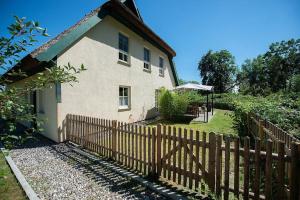 a house with a wooden fence in front of it at Naturferienhaus 2 in Mellnitz