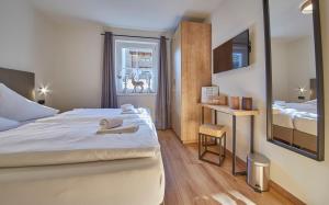ein Hotelzimmer mit einem großen Bett und einem Fenster in der Unterkunft Appartement Iglsberg Top 7 in Saalbach-Hinterglemm