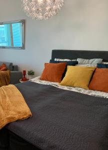 uma cama com almofadas coloridas em cima em StarHomes Studio Apartments em Oulu