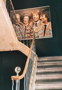 eine Treppe mit einem Plakat der Beatles an der Wand in der Unterkunft Royal Hôtel in Nîmes