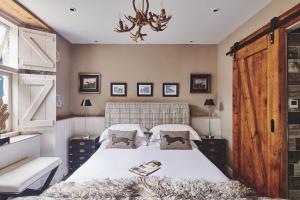 a bedroom with a large bed and a chandelier at Mimosa Cottage in Rhoose