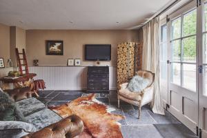 a living room with a couch and a tv at Mimosa Cottage in Rhoose