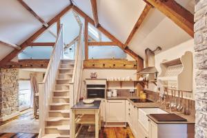 a kitchen with wooden ceilings and wooden floors and a staircase at Lotus Cottage in Rhoose