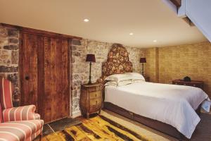 a bedroom with a bed and a stone wall at Lotus Cottage in Rhoose