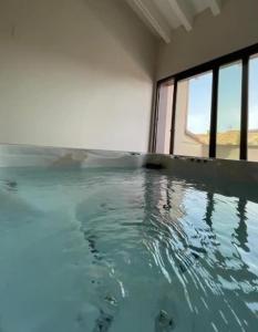 uma grande piscina de água num quarto com uma janela em Casa Rural L'Alba em Catí