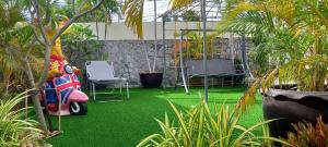 a garden with green grass and two chairs and a scooter at VIEWBOR VILLA - PATTAYA HOLIDAY HOUSE WALKING STREET 4 bedrooms in Pattaya South