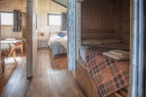 a bedroom with two beds in a wooden room at Three Cliffs - Safari Glamping Tent - Llangennith in Llangennith