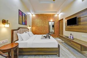 een hotelkamer met een bed en een televisie bij Hotel King's Turban in Jaipur