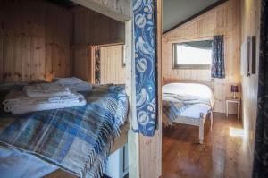 a bedroom with two beds in a wooden cabin at Worms Head - Safari Tent - Llangennith in Llangennith