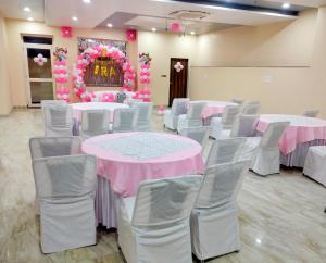 een kamer met tafels en stoelen en roze bloemen bij Hotel King's Turban in Jaipur