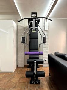 einen Fitnessraum mit einem Stuhl und einer Couch in einem Zimmer in der Unterkunft Appartamento Ebhouse in Capiago Intimiano