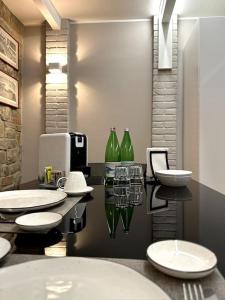 ein Badezimmer mit 2 Waschbecken und grünen Glasflaschen in der Unterkunft Appartamento Ebhouse in Capiago Intimiano
