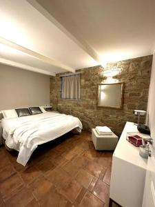 ein Schlafzimmer mit einem großen Bett und einer Steinmauer in der Unterkunft Appartamento Ebhouse in Capiago Intimiano