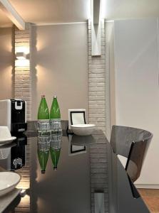 ein Badezimmer mit grünen Glasvasen auf der Theke in der Unterkunft Appartamento Ebhouse in Capiago Intimiano