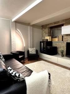 ein Wohnzimmer mit einem Sofa und einem TV in der Unterkunft Appartamento Ebhouse in Capiago Intimiano
