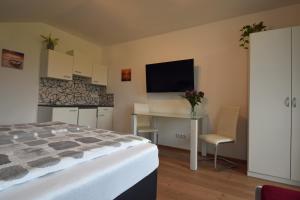 a bedroom with a bed and a desk and a tv at Almblick Energiequelle in Bad Mitterndorf