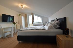 a bedroom with a large bed with a tv on the wall at Almblick Energiequelle in Bad Mitterndorf