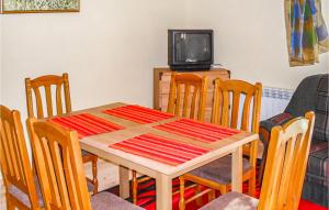 a dining room with a table and chairs and a tv at Awesome Home In Grunwald With 3 Bedrooms And Wifi in Mielno