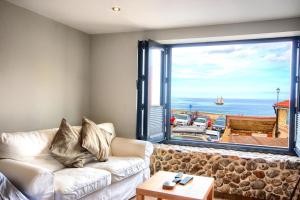 een woonkamer met een bank en een groot raam bij Sea Spray in Sheringham
