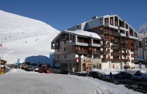 a large building with cars parked in a parking lot at Résidence Odalys Le Hameau du Borsat in Tignes