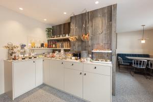 a kitchen with white cabinets and a table with chairs at Haus Verwall in Obergurgl