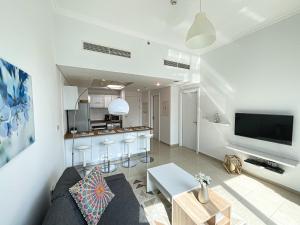 a living room with a couch and a kitchen at HiGuests - Incredible apartment at the top of Dubai Marina in Dubai