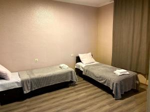 a room with two beds with towels on them at Hotel Tao in Telavi