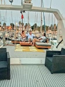 un groupe de personnes assises sur le pont d'un bateau dans l'établissement Loc de cabines sur Yacht, à Gruissan