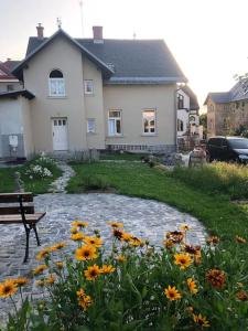 una casa con una panchina e fiori nel cortile di Vila se zahradou a s parkováním v ceně a Jablonec nad Nisou