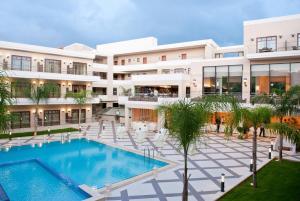 an exterior view of a building with a swimming pool at Porto Platanias Beach Resort & Spa in Plataniás