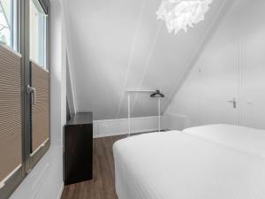 a white bedroom with a bed and a window at Holiday Home in Lochem with Garden View in Lochem