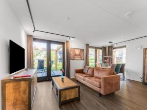 a living room with a couch and a tv at Holiday Home in Lochem with Garden View in Lochem
