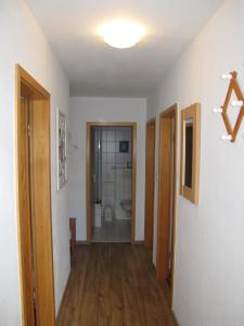 une chambre vide avec un couloir avec des portes et une salle de bains dans l'établissement FeWo BENINGA DORN201, à Dornum