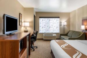 a hotel room with a bed and a flat screen tv at Quality Inn Placentia Anaheim Fullerton in Placentia