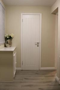 a white door in a room with a kitchen at Dorcas Lodge - Lovely 5 Bedroom home with free parking and Wi-Fi in Nevendon