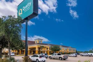 un cartello stradale di fronte a un grande edificio di Quality Inn & Suites Granbury a Granbury