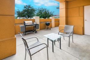 eine Terrasse mit Stühlen, einem Tisch und einem Grill in der Unterkunft Quality Inn & Suites Granbury in Granbury