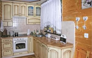 een keuken met houten kasten, een wastafel en een fornuis bij Amazing Home In Molza With Kitchen in Molza