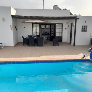 a swimming pool in front of a house at Villa julima in Playa Blanca