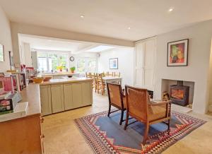 a kitchen with a table and chairs and a fireplace at Dolphin Cottage - Hayling Island in South Hayling