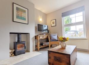 a living room with a wood stove and a tv at Dolphin Cottage - Hayling Island in South Hayling