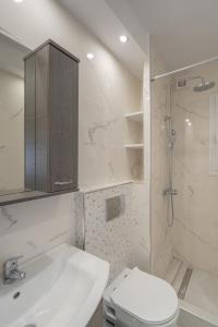 a bathroom with a toilet and a sink and a shower at Comfy Apt next to metro in Athens