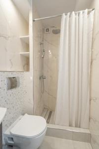 a bathroom with a shower curtain and a toilet at Comfy Apt next to metro in Athens