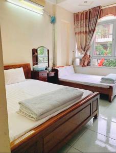 Un pat sau paturi într-o cameră la Khách sạn Hoàng Trang