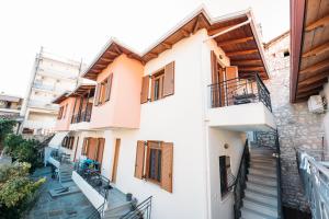 a white building with wooden shutters and stairs at Muses old town ioannina Urania in Ioannina