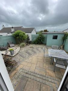 a patio with a table and chairs and a house at Holiday Home- Portballintrae in Portballintrae