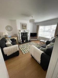 a living room with two couches and a fireplace at Holiday Home- Portballintrae in Portballintrae